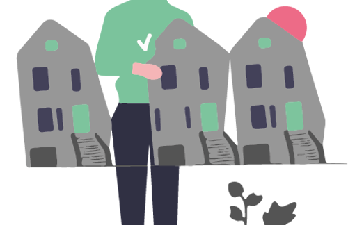 En person som står vid ett bord med minitayrer av bostadshus